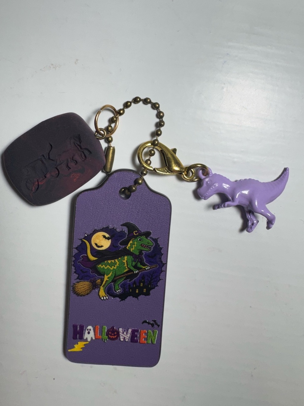 Coach purple hangtag with purple dinosaur charm